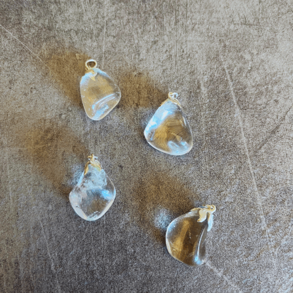 Kettinghanger met een bergkristal. Bergkristal reguleert energie, absorbeert energie, geeft energie en slaat energie op naar gelang wat er nodig is in een bepaalde situatie.