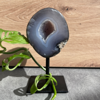 Agaat op standaard. Agaat werkt aardend, stabiliserend en beschermend. Het helpt jezelf accepteren en helpt vertrouwen hebben in jezelf.