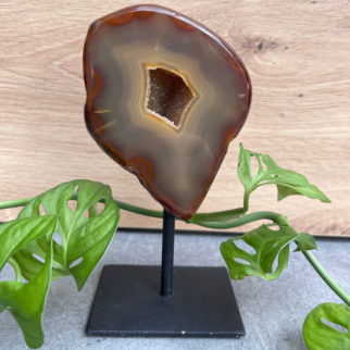 Agaat op standaard. Agaat werkt aardend, stabiliserend en beschermend. Het helpt jezelf accepteren en helpt vertrouwen hebben in jezelf.