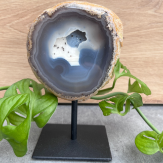 Agaat op standaard. Agaat werkt aardend, stabiliserend en beschermend. Het helpt jezelf accepteren en helpt vertrouwen hebben in jezelf.