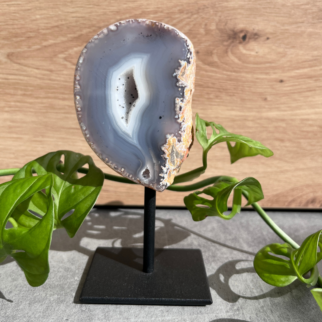 Agaat op standaard. Agaat werkt aardend, stabiliserend en beschermend. Het helpt jezelf accepteren en helpt vertrouwen hebben in jezelf.